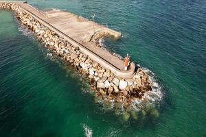 Breakwater with lighthouse as a guide for maritime navigation.Aerial drone view photo