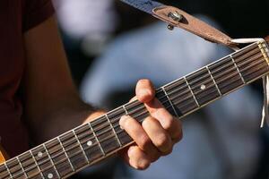 Fingers forming chord on steel string acoustic guitar, Musician playing chords on acoustic guitar strings photo