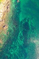 drone shot of sandy beach merging with rocky ocean floor. Aerial drone overhead view photo