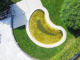 Aerial zenith perspective of an unmaintained geometric pool with soiled water. photo