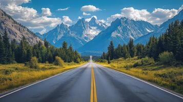 Lone Asphalt Road Leads Through Vibrant Landscape Towards Majestic Mountain Range Under a Clear Sky photo