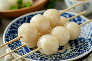 Close-up of Sweet Tangyuan Dumplings on Skewers in a Decorative Bowl. photo