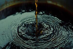 Liquid Pouring into Dark Surface Creating Concentric Ripples. photo