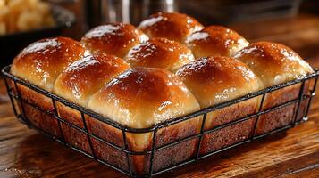 Golden Brown Dinner Rolls in a Wire Rack, Close Up. A mouthwatering image of freshly baked, glazed dinner rolls. photo
