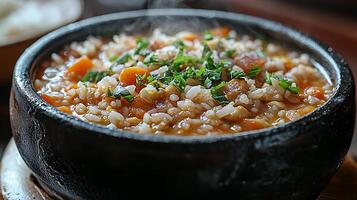 Close up of Steaming Rice Dish with Carrots and Herbs in a Dark Bowl. photo
