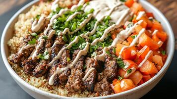 Grilled Steak and Quinoa Bowl with Roasted Tomatoes and Creamy Dressing. A close up view of a delicious and healthy meal. photo