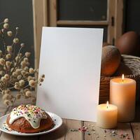 A blank sheet of paper on a rustic wooden table, surrounded by Easter treats, lit candles, and delicate sprigs, creating a warm and inviting holiday scene photo