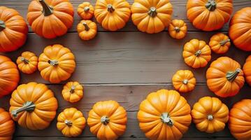 A rustic surface is bordered by vibrant orange pumpkins of varying sizes, creating a warm photo