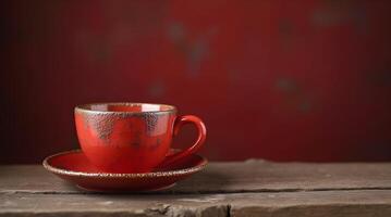 A rustic red teacup and saucer with a speckled, worn texture, set against a deep red background, conveying a vintage and artisanal feel. photo
