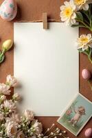 A blank sheet of paper pinned to textured surface, surrounded by colorful Easter eggs, delicate flowers, and a vintage postcard, photo