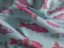 Vibrant fabric featuring colorful fish patterns on light blue background, perfect for creative projects and home decor photo