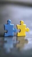 Two puzzle pieces in blue and yellow colors symbolize connection and teamwork, evoking sense of unity and collaboration photo