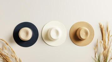 Three hats on a white wall with some dry grass photo