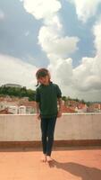 A Joyful Child Happily Dancing on a Rooftop with a Stunning Scenic View All Around video