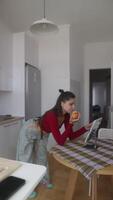 A Woman Enjoying a Delicious Apple While Relaxing in a Stylish and Modern Kitchen Space video