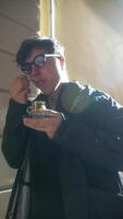 A Young Man Taking Delight in Enjoying a Warm Beverage while Relaxing in Natural Light video