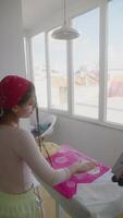 A woman is skillfully preparing dough in her bright kitchen, filled with sunlight video