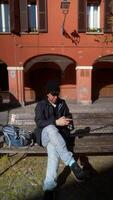 Relaxing casually outdoors in an urban area while using a smartphone for communication video