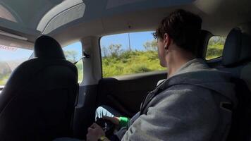 A young passenger is enjoying a scenic drive while relaxing in a modern, comfortable vehicle video