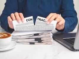 Close-up of a businessman tearing up a contract while sitting at the table photo
