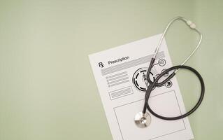Top view of a stethoscope over the medical prescription sheet on a green background photo