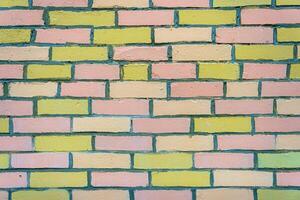A wall made of pink and yellow bricks. The bricks are arranged in a pattern. photo