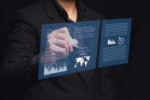 Businessman uses a pen to sign electronic documents on a virtual screen while standing on a black background photo