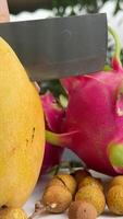 A slice of mango is on a plate with a whole mango on top. The slice of mango is cut into small pieces video