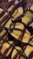 Closeup top view of Rotating chocolate powder and cream, banana, almonds on waffles video