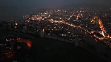 Breathtaking aerial night view of Luzern, Schweiz, featuring glowing streets, historic architecture, Vierwaldstaettersee and Reuss under misty sky, creating a magical and picturesque cityscape. video