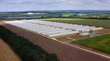 Large farm in rural place in summer. Modern agricultural buildings surrounded by amazing nature in the countryside. Aerial view. video