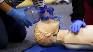 Training course on a manikin. Practitioners giving breath exercises on a dummy at resuscitation. Compression during heart attack on a mannequin. video
