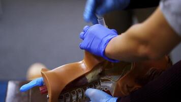 Practical course on a dummy's head. Student trying medical exercise at giving a resuscitation on a mannequin in the training center. Close-up. video