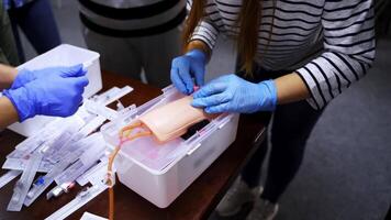 Training injection into a vein on a mannequin arm. Student studying how to put dropper in a training center. Medical practice. video
