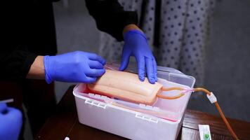 Practical lesson with an injection. Practitioner doing a training injection into a vein on a dummy. Procedure of pricking into manikin arm. Close-up. video