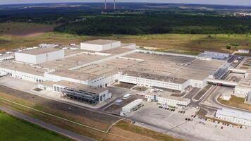 Industrial zone in the countryside. Huge commercial plant on field in summer nature. Modern factory among green environment. Aerial view. video