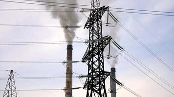 Problem of environmental pollution and air. High voltage towers and massive smoke from industrial pipes on the sky background. video