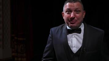 Portrait of a comedian talking. Cheerful actor in suit telling funny stories and gesticulating a lot. Man performing on stage. video