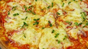Delicious pizza. Melted cheese and green sprouts on pizza. Appetizing pizza spinning on the table. Close-up. video