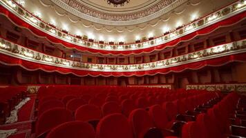 Empty seats in the auditorium of the opera house. Beautiful theatrical hall with rows of red chairs. Three tiers in classical theater with no people. video