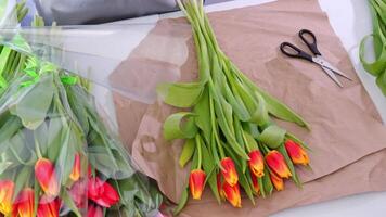 Arranging vibrant tulips, a stepbystep floral wrapping process on rustic table video