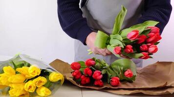 Florist arranging vibrant tulips and daffodils in a creative display for spring bouquet video
