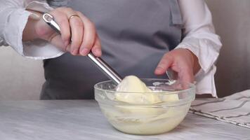 Demonstration of a flowing smooth cream for a cake manually in a glass bowl to prepare for baking video