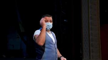 Man in medical mask on scene. Actor in protective mask is talking and gesticulating a lot while standing on stage in the theater. Pandemic in the world. video