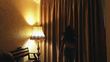 Happy optimistic young woman opens window. Smiling girl running happily to the window and opening dark curtains in luxury hotel room. video