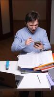 vertical Stressed office worker shouting on phone while pointing at documents video