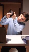 vertical Businessman checking empty wallet at office desk video