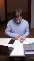 vertical Office worker counting remaining coins at desk with laptop and files video