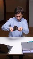 vertical Office worker showing empty wallet at desk with laptop and folders video