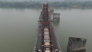 Aerial view of Long Bien Bridge in Hanoi, Vietnam, with train and motorbikes crossing over the Red River on foggy day. Historic steel structure with daily traffic. video